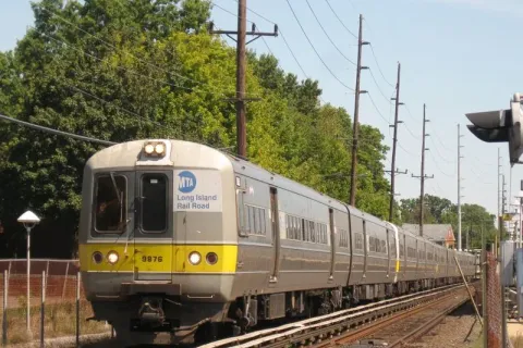 A Long Island Rail Road commuter train arriving at a grade crossing.